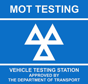 Blue sign with white text and three-triangle logo. Text reads: "MOT TESTING, VEHICLE TESTING STATION APPROVED BY THE DEPARTMENT OF TRANSPORT." Expert garage mechanics also offer DPF cleaning for your vehicle's optimal performance.